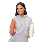 A drink bottle in rust and cream colours with double-wall insulation, featuring a logo and held by a smiling woman.