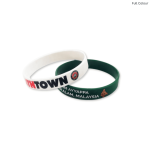 A pair of silicone wristbands, one white with branding and one green, featuring decorative elements.