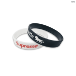 Two silicone wristbands, one black with a logo and one white with red text, displayed against a plain background.