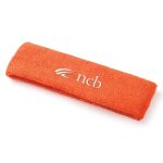 An orange plush terry sport headband with a logo on the front.