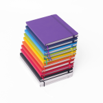 A stack of A5 notebooks in various bright colours, featuring elastic closures and a sleek design.