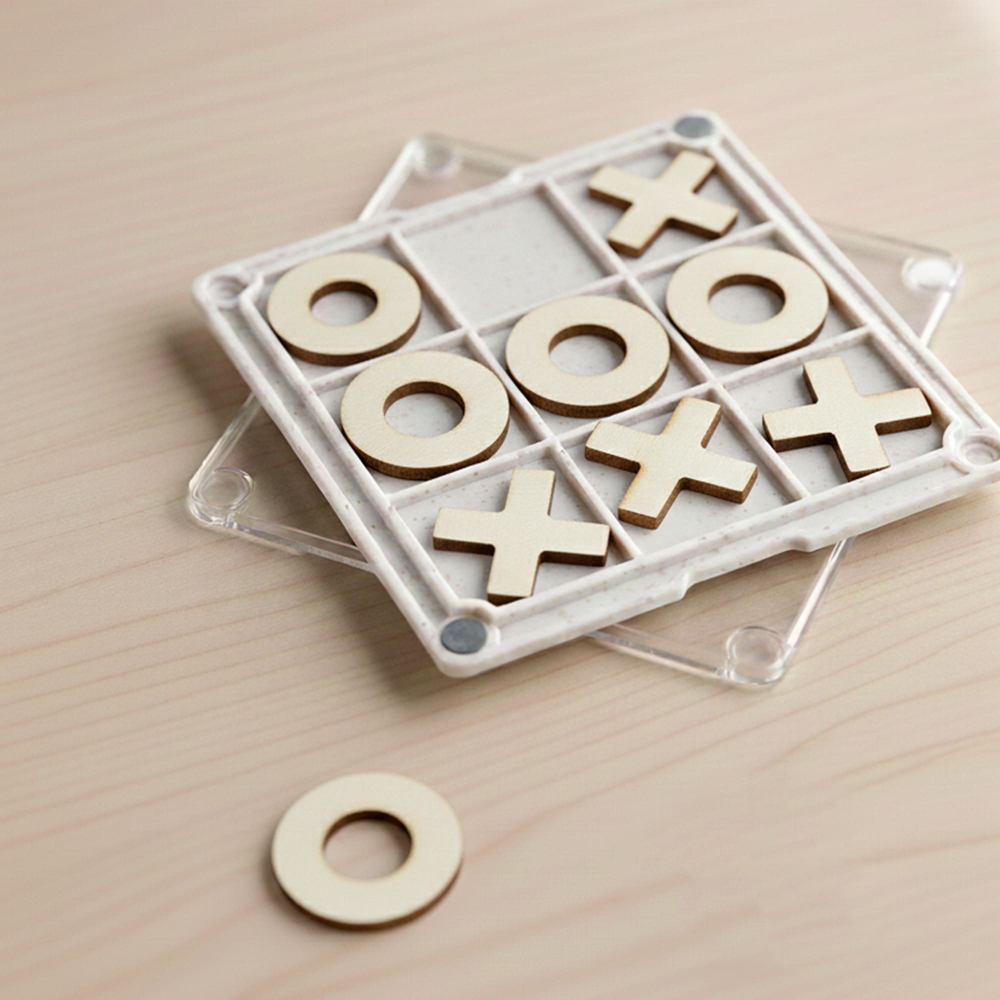 A Tic Tac Toe board game coaster with a clear base, featuring wooden X and O pieces in a grid pattern. Tic Tac Toe Board Game Coaster - Image 1