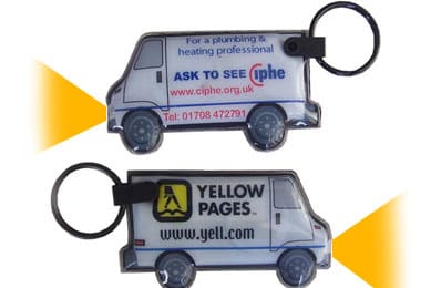 A promotional PVC keyring shaped like a van, featuring an LED light and logos on both sides. PVC Keyring with LED Light - Image 1