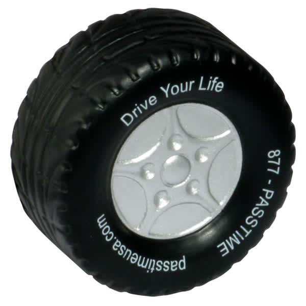 A black tire-shaped stress reliever with a silver wheel design and a logo on the side. Tire Shape Stress Reliever - Image 1