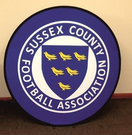 A round pop-up banner with a purple background and a central shield design featuring six yellow birds. It includes a logo. Round Pop Up Banner 1200mm Diameter - Image 1