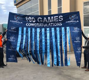 A large blue banner with ribbon elements, featuring text celebrating "100 Games" and a logo. Run Through Rectangle Banner - Image 1