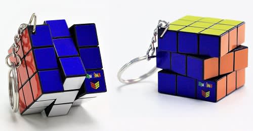 A Rubik's Cube keyring featuring blue, red, orange, green, and white squares with a keyring attachment and branding. Rubik's Cube Keyring 3x3 34mm (stock) - Image 1