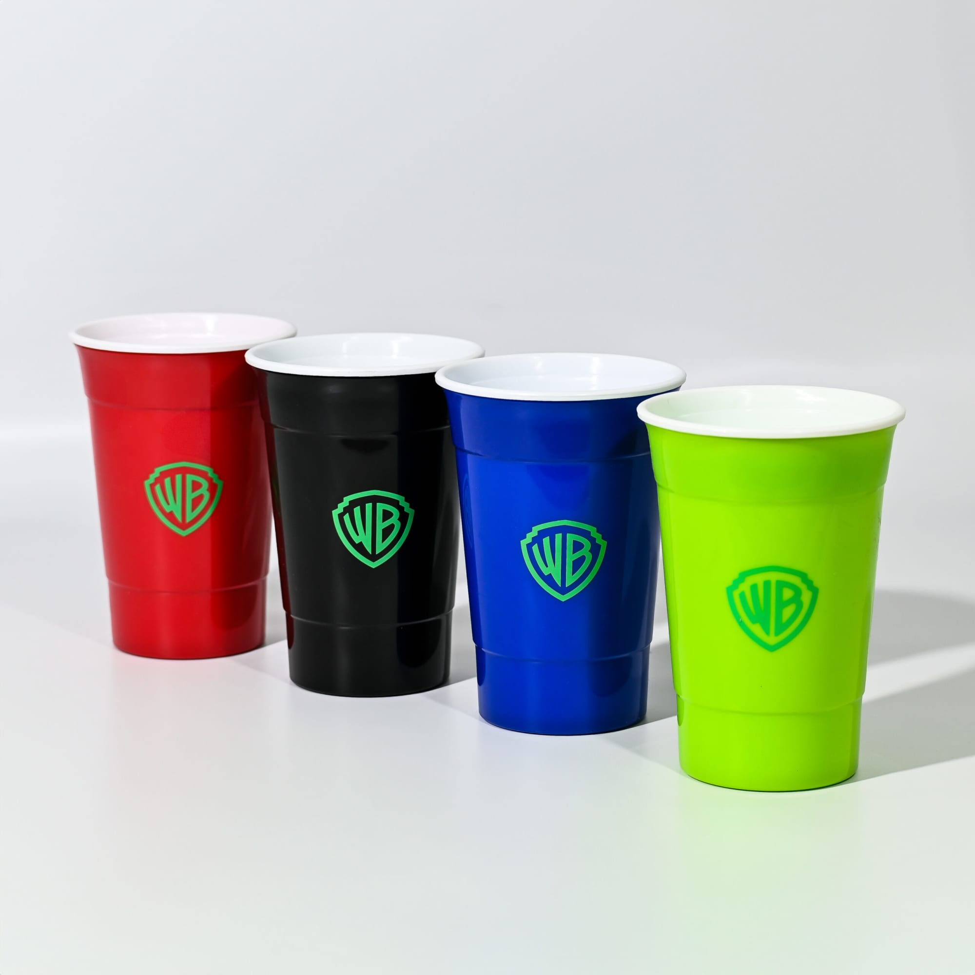 A set of four double wall plastic cups in red, black, blue, and green, featuring a logo on each. Double Wall Party Cup 470mL - Image 1