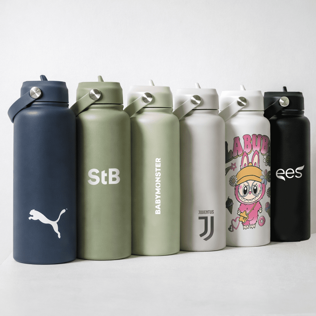 A drink bottle collection with navy, olive, white, and black colours, featuring various logos and designs. Byron 1L Drink Bottle - Image 1