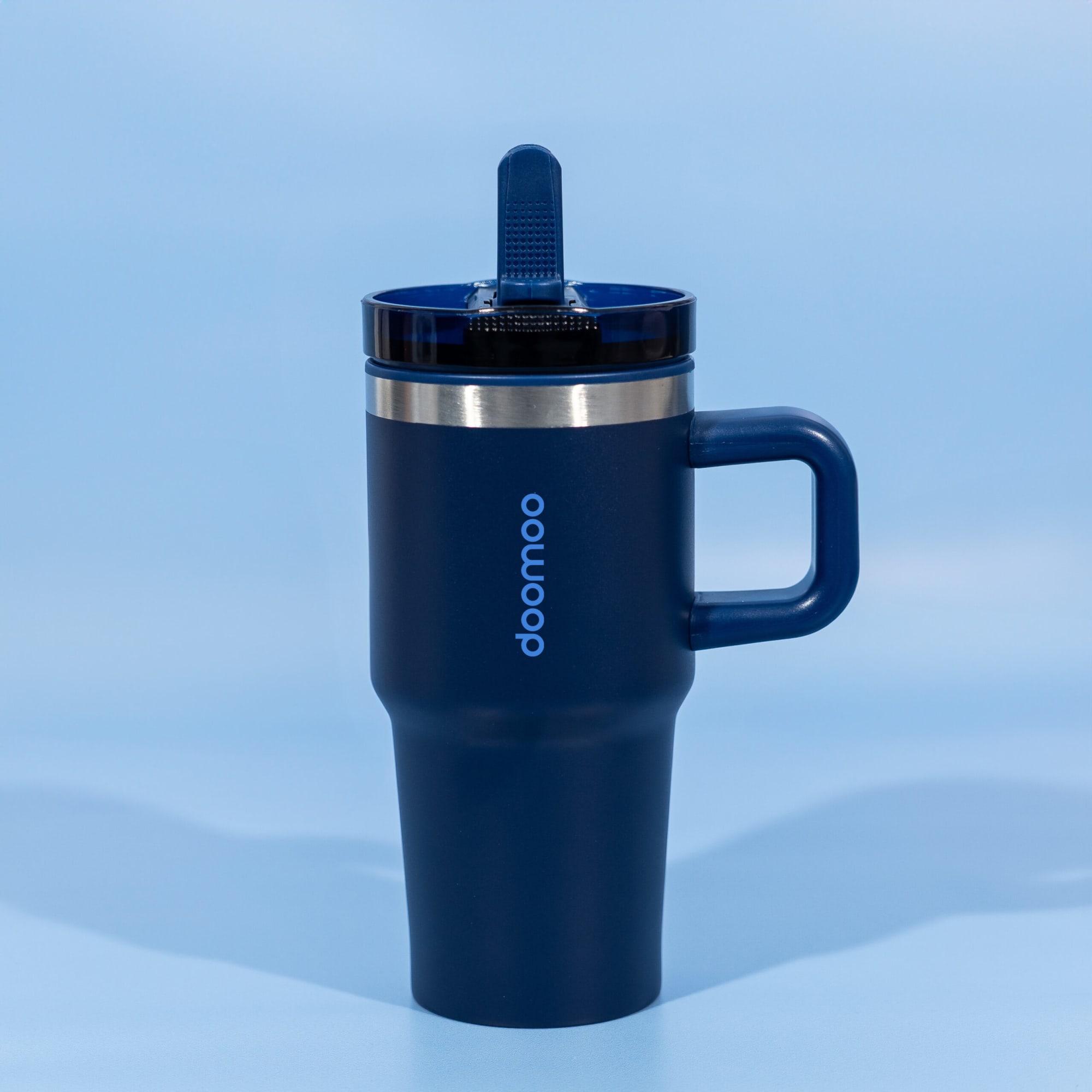 A drink bottle featuring a navy blue exterior, double wall insulation, and a secure lid with a straw. Nomad 600ml Double Wall Mug - Image 1