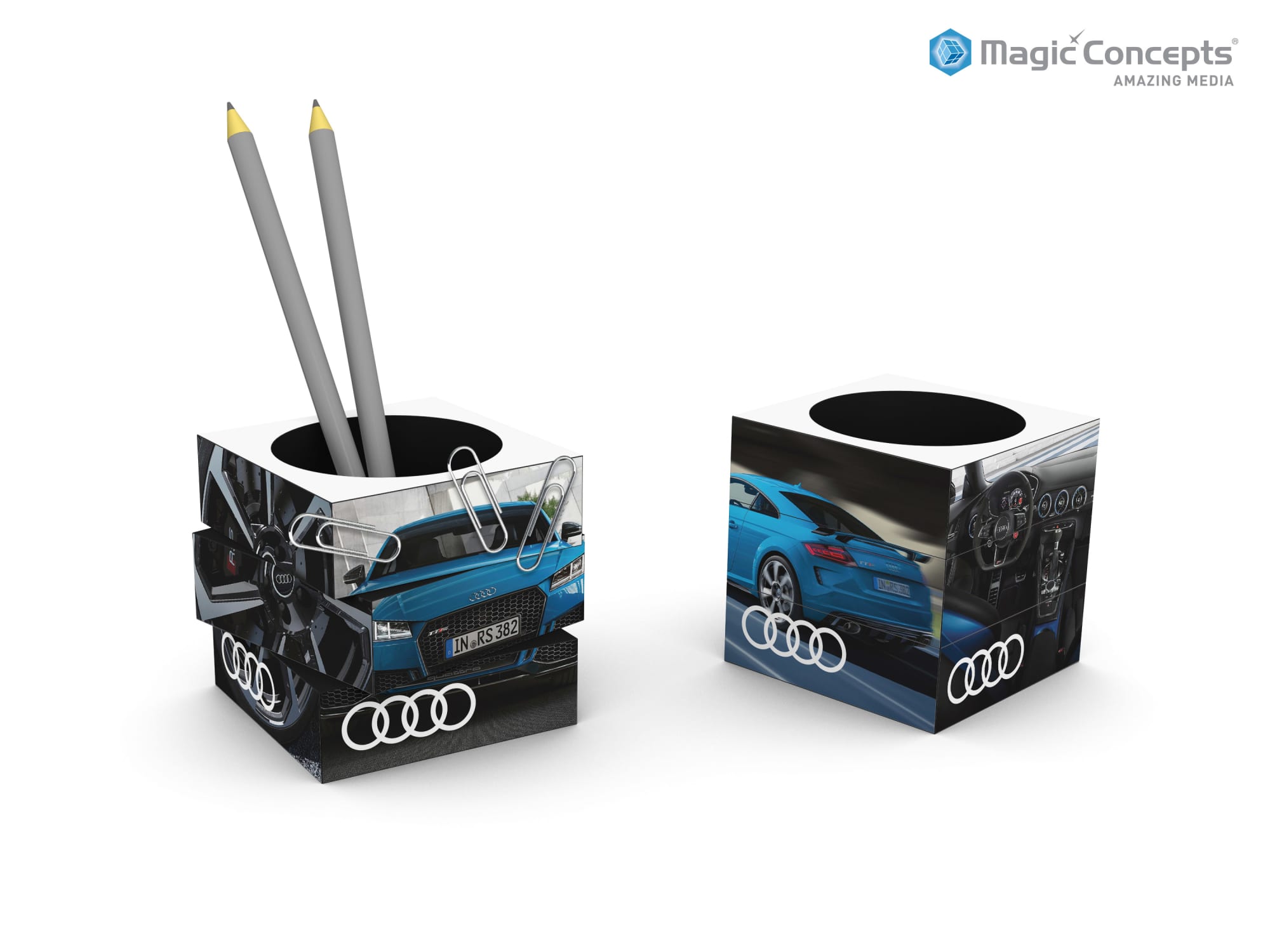 A cubic pen pot with a white and black design featuring images of a blue car and has a logo. Contains two grey pencils. Magic Sliding Pen Pot - Image 1