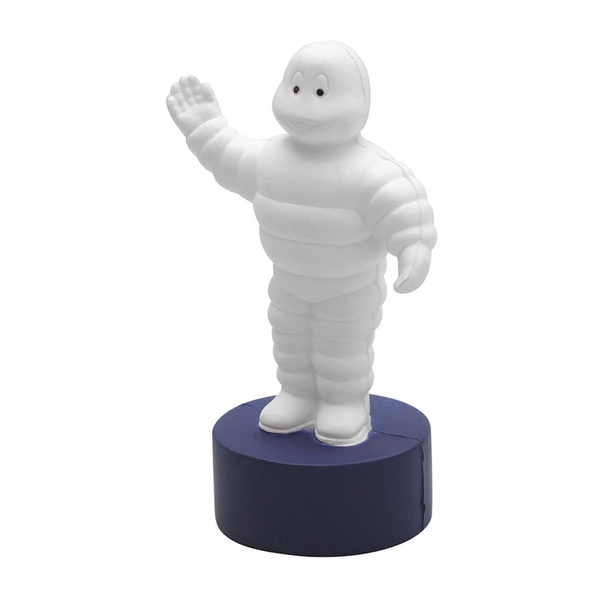 A stress toy featuring a white, cartoonish figure with arms raised, standing on a navy blue base. Stress Tyre Man - Image 1