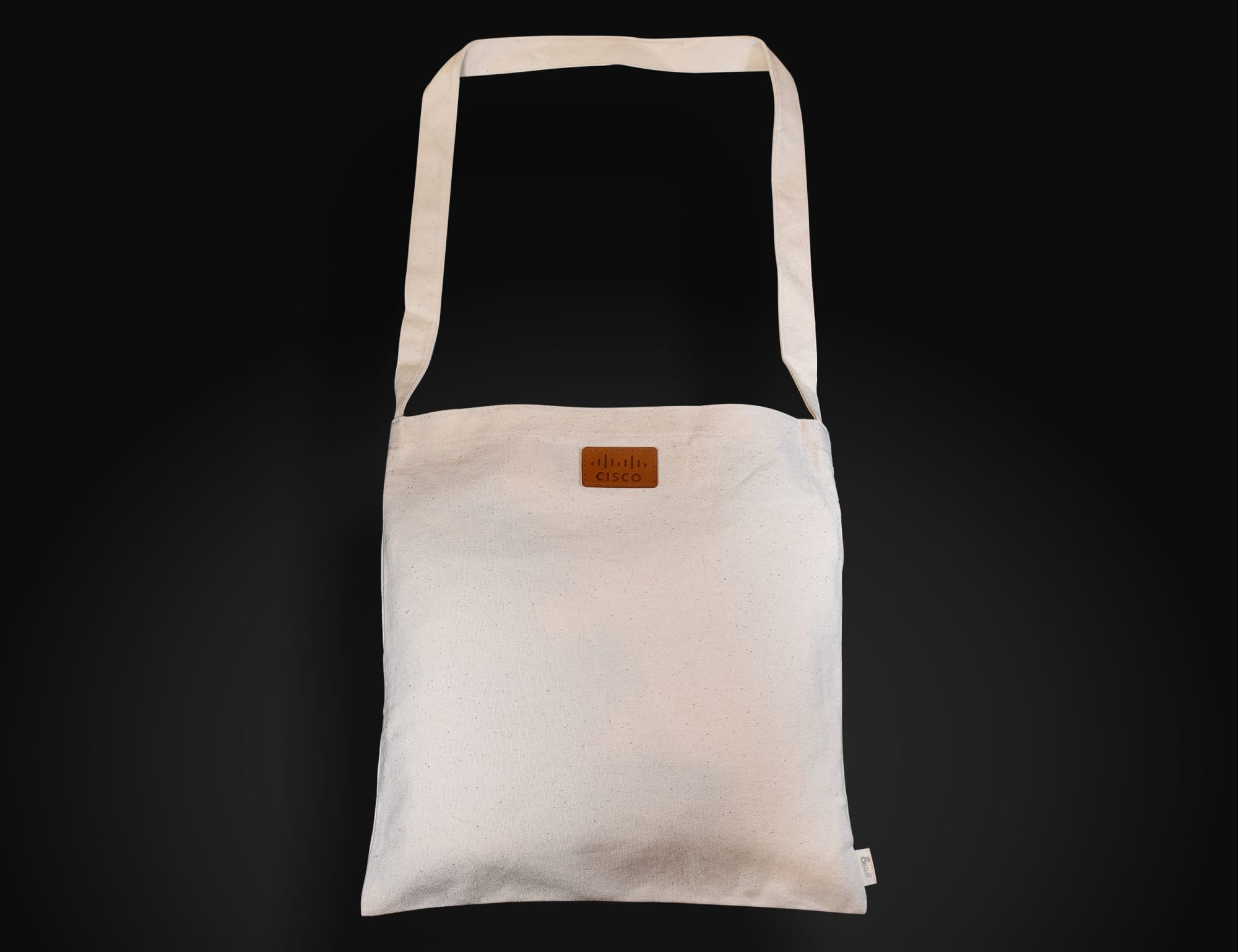 A light-coloured, long-handled shoulder bag with a logo on the front, featuring a simple, minimal design. Calico Long Handle Shoulder Bag 38x38cm - Image 1