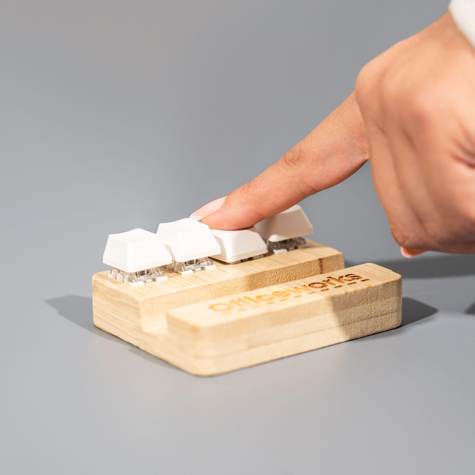 A bamboo stand holder with three white key-shaped buttons, designed for stress relief, featuring a logo. Bamboo Stand Holder Key Pressing Stress Reliever - Image 1