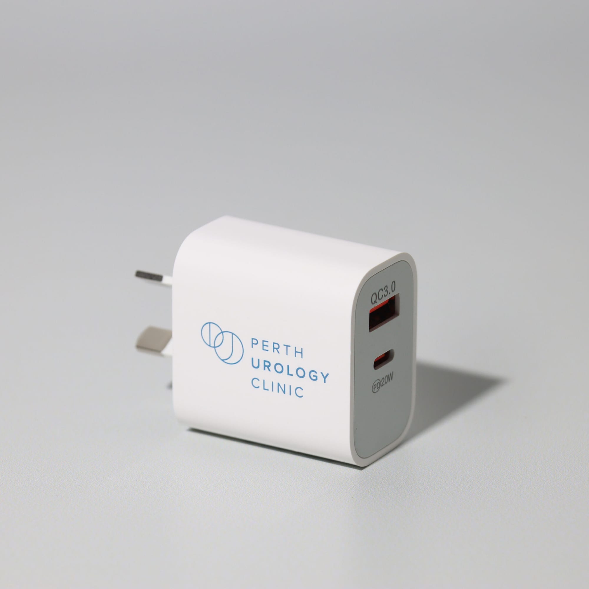 A white fast charge adapter with a USB-C port and a logo on the side, featuring Australian plug prongs. Tebogo 20W fast charge adapter - Image 1