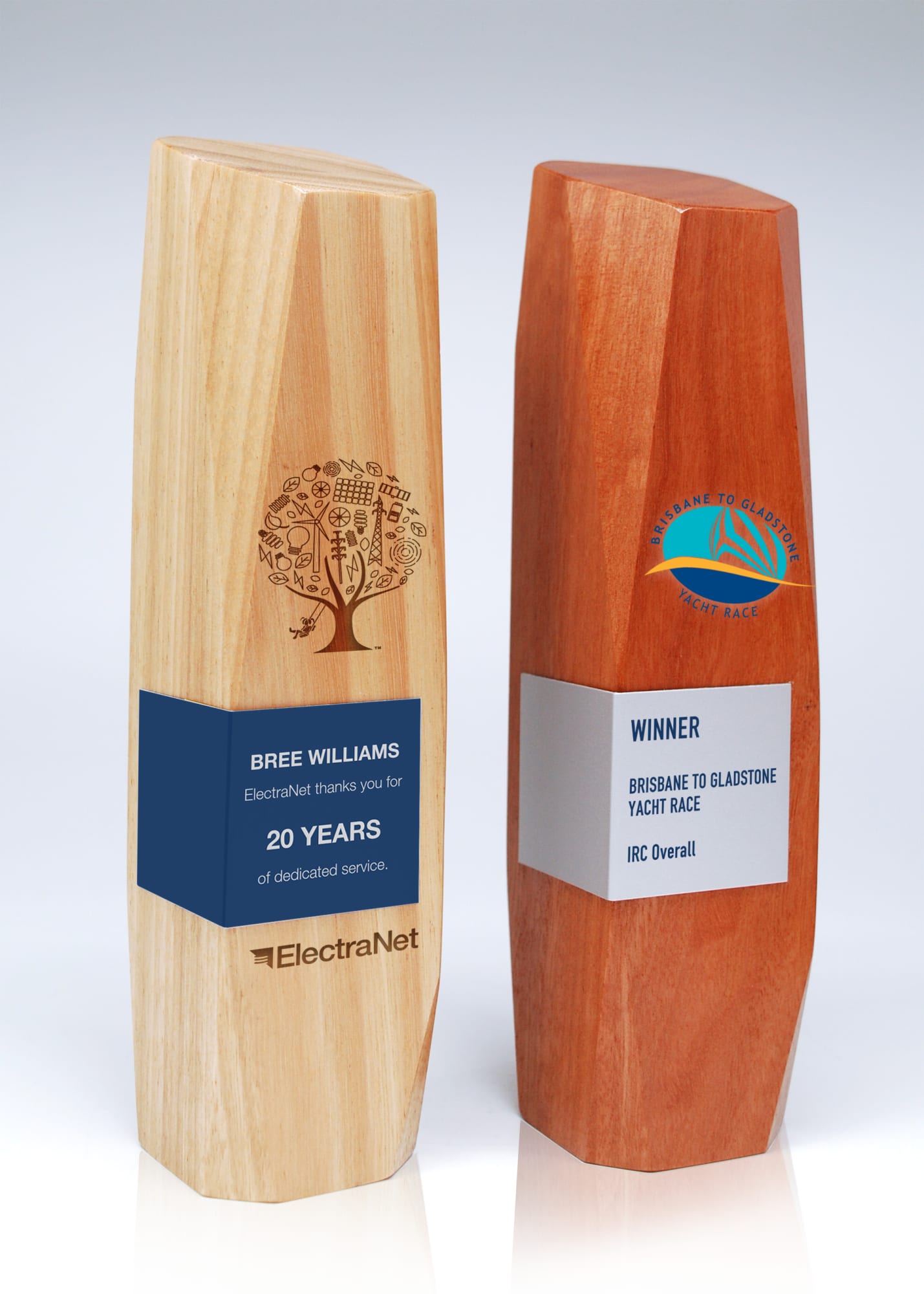 Two wooden trophies made of light and dark timber with engraved designs and metal wraps, showcasing a winner's title. Australian Select Grade Blackbutt Icon Trophy with Metal Wrap - Image 1
