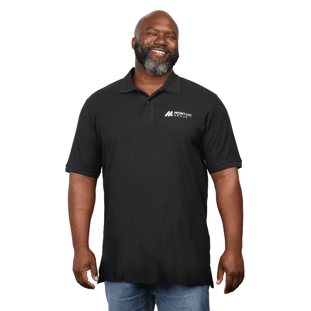 A man wearing a black eco-friendly polo shirt with a logo on the chest, smiling and standing. IZU Everything Performance Eco Polo - Men's - Image 1