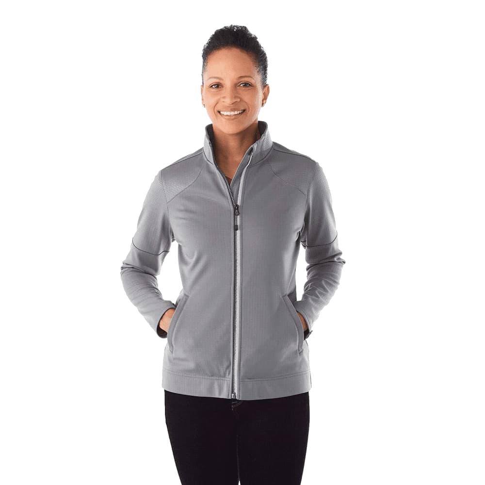A woman is wearing a grey full zip performance jacket with thumb holes, featuring a sleek design and a logo. Women's Senger Knit Full Zip Performance Jacket w/ Thumb Holes - Image 1