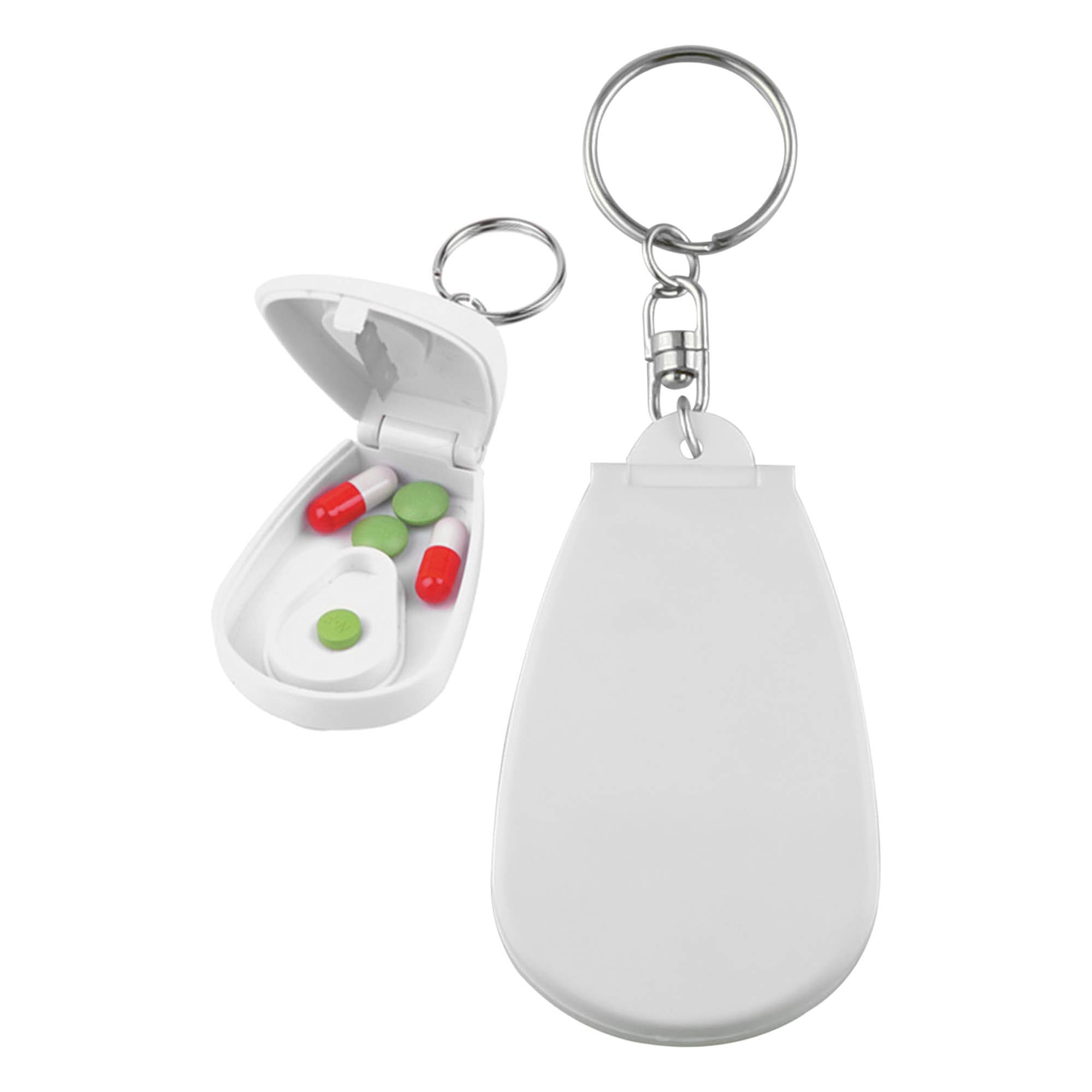 A white pill cutter with a keychain attachment, featuring an open compartment with green and red pills inside. Pill Cutter - Image 1