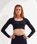 A ribbed, seamless black crop top with long sleeves and a scoop neckline. It features a fitted design and has a logo.