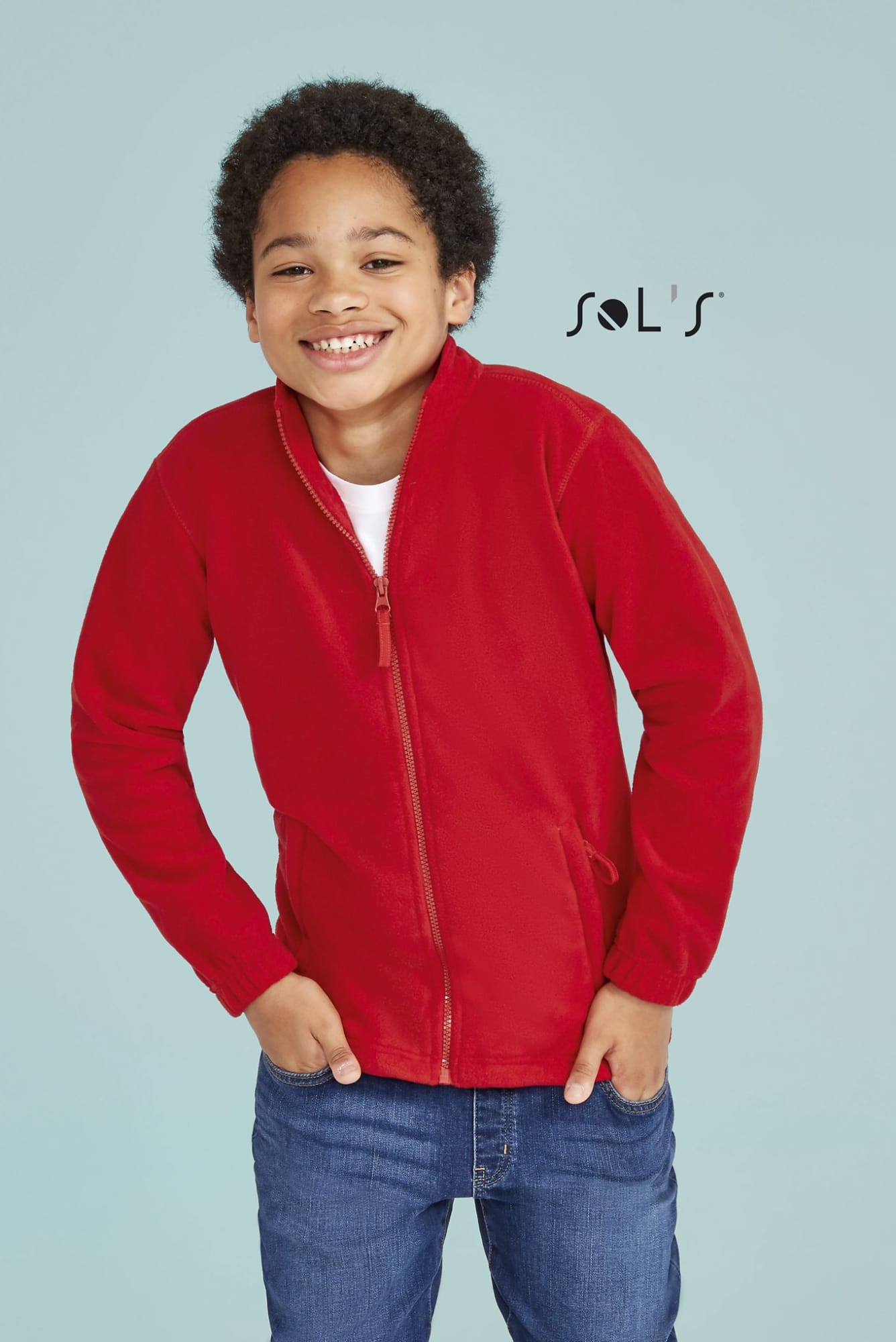 A red fleece jacket with a zip, displayed on a smiling child against a light blue background. It features a logo. NORTH KIDS KIDS' ZIP FLEECE JACKET - Image 1
