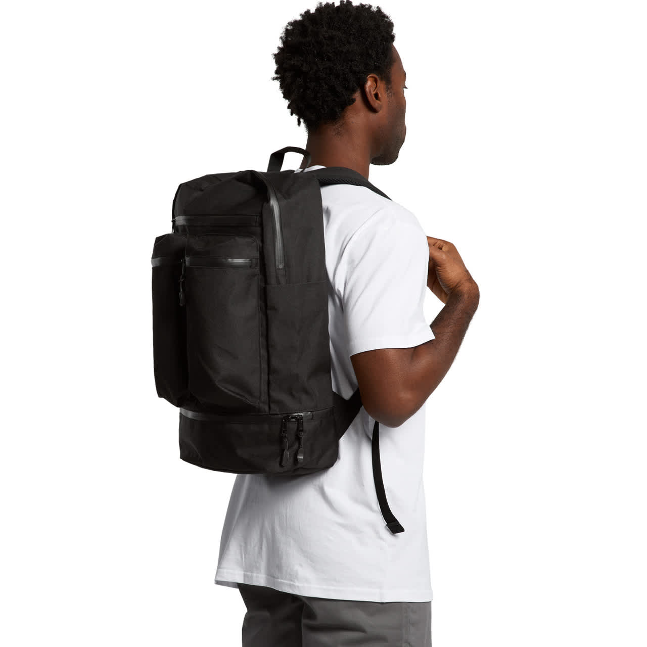 A black recycled travel backpack is worn by a person from a side angle, showcasing multiple compartments and a sleek design. Recycled Travel Backpack - Image 1