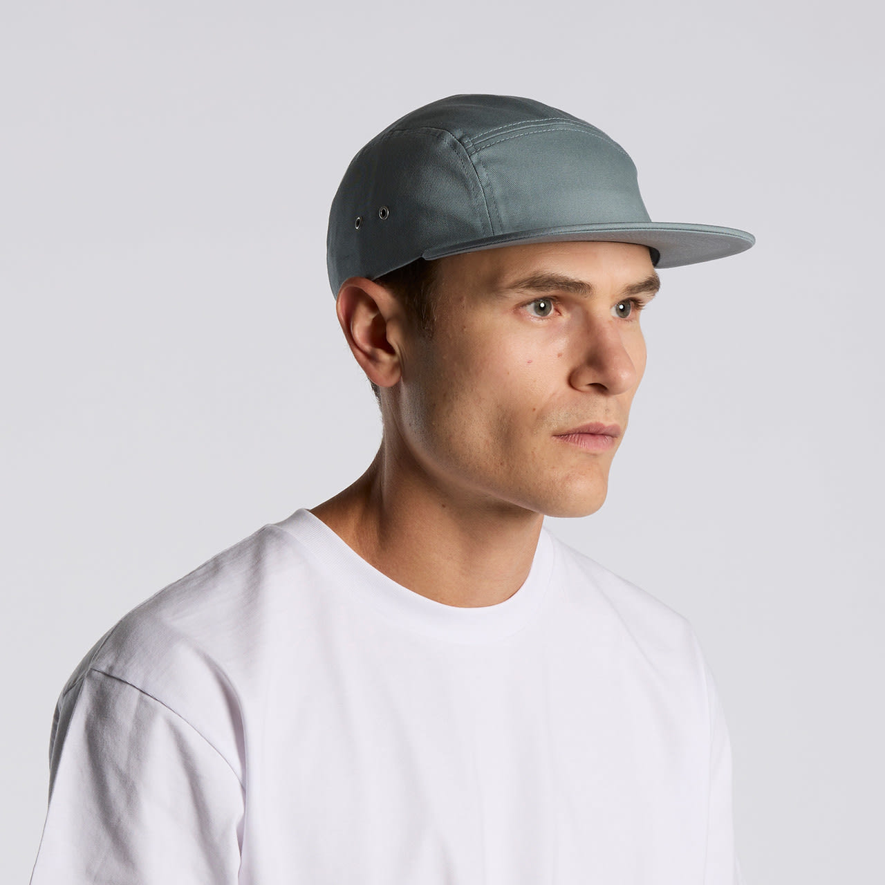 A five-panel cap in a soft blue-grey colour worn by a model, featuring a subtle logo. Finn Five Panel Cap - Image 1