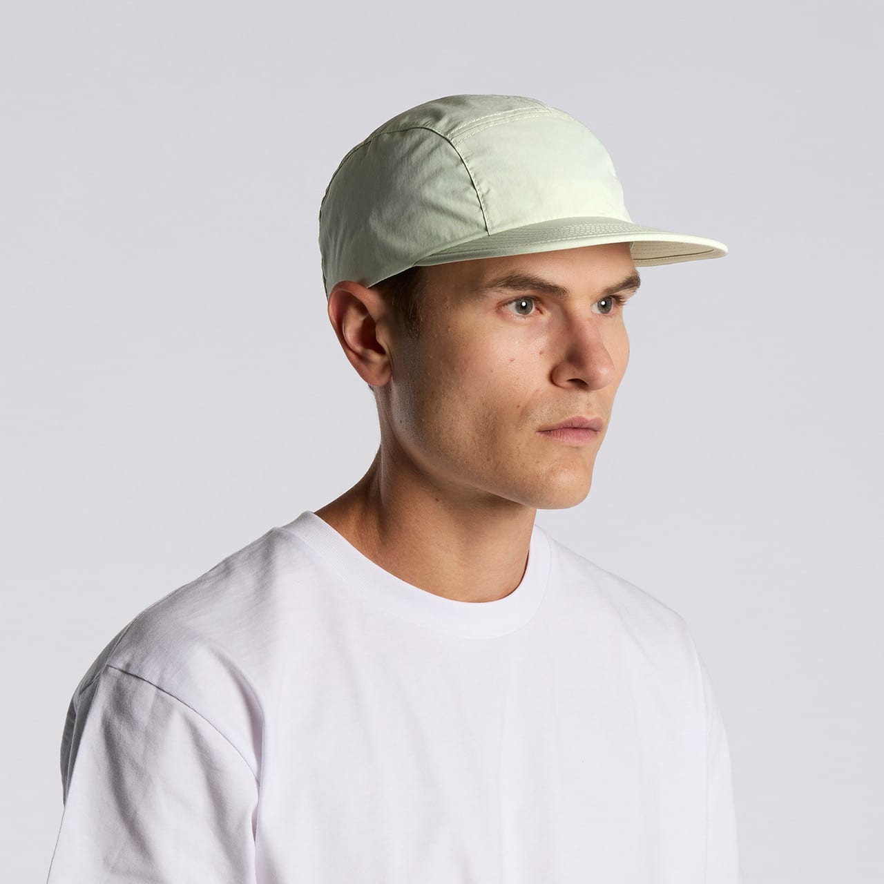 A light green nylon cap with a stiff brim, worn by a model against a plain background. Finn Nylon Cap - Image 1