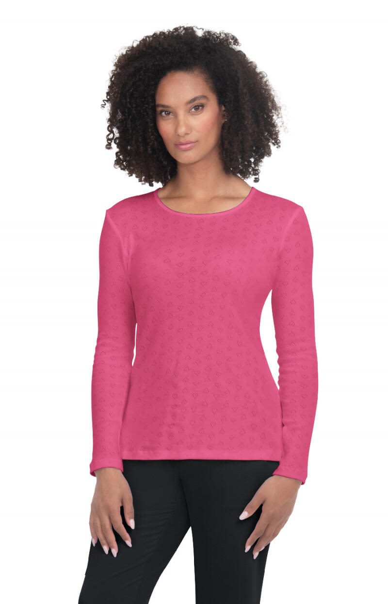 A pink long-sleeve top on a model, featuring a round neckline and a textured pattern. It has a logo on it. Rohan Tee - Image 1
