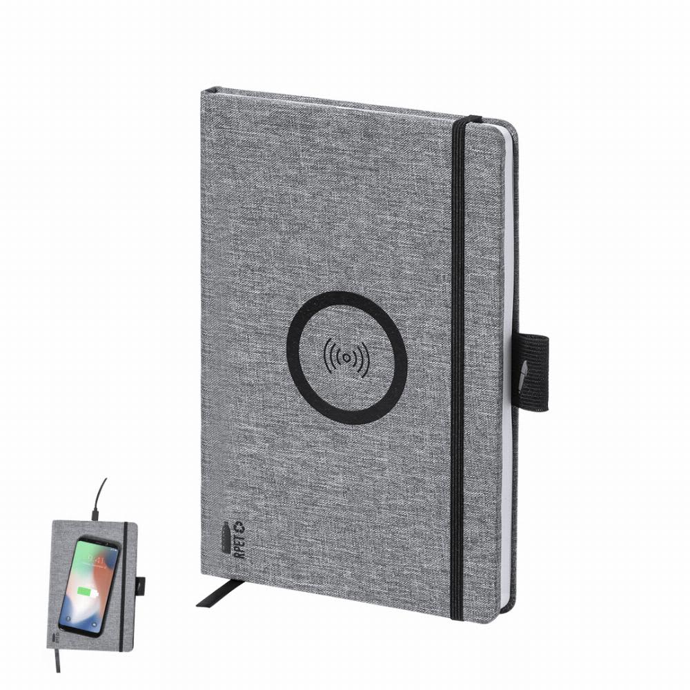 A grey notebook with a wireless charging pad and a small phone resting against it. It features a black logo. Bein - Image 1