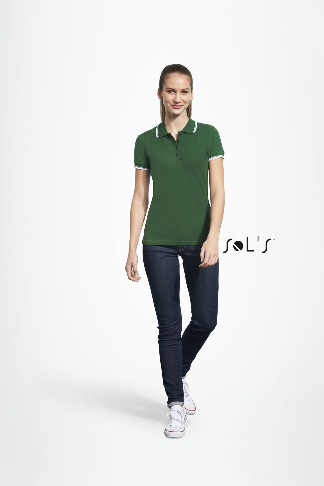 A green women's polo shirt made of 100% combed ring spun cotton, featuring a logo, paired with denim jeans. Polo shirt women's 100% combed ring spun cotton PRACTICE - Image 1