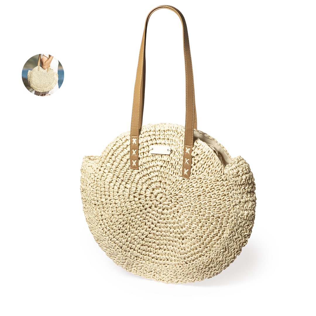 A round, natural-coloured tote bag with tan leather handles and a logo. It features a woven, textured design. Mandy Bag - Image 1