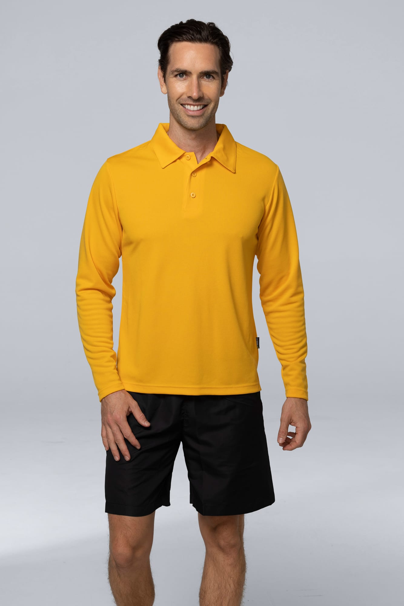 A men's long-sleeve polo shirt in bright yellow, paired with black shorts. The shirt features a logo. BOTANY MENS POLOS - Image 1