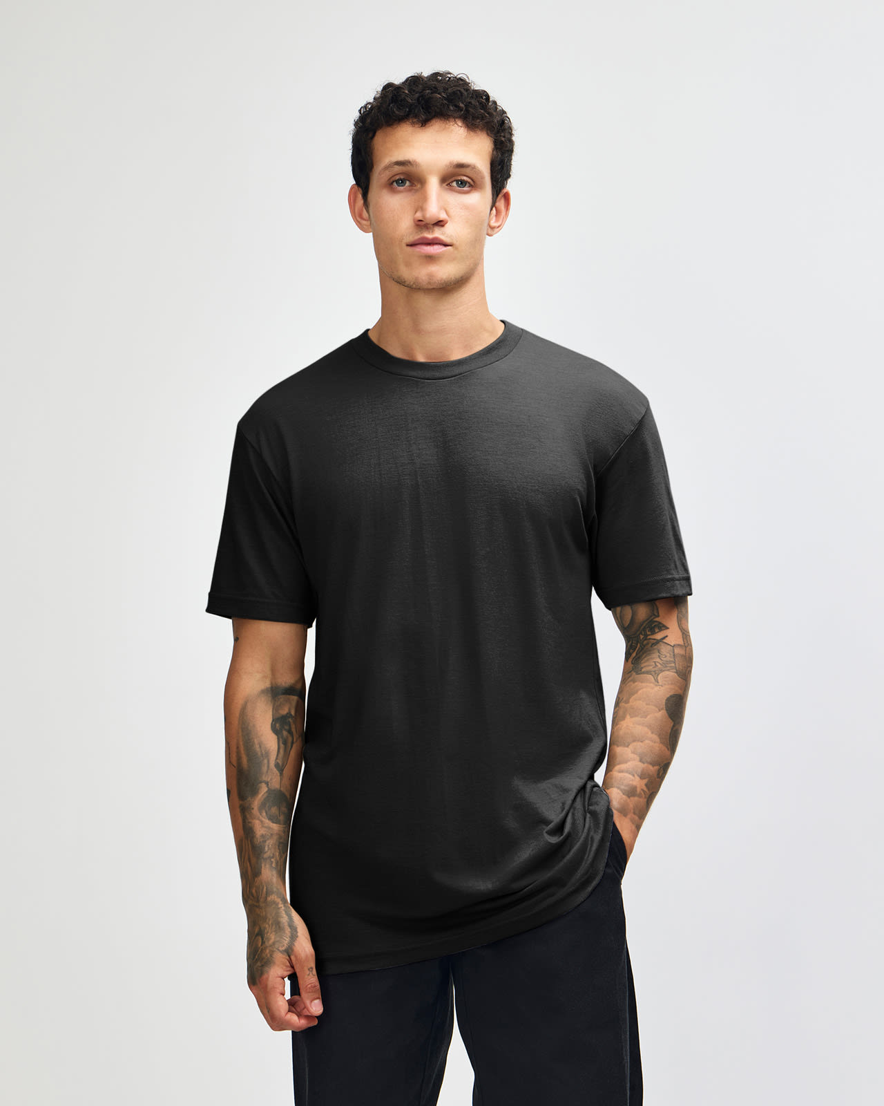 A unisex black CVC short sleeve t-shirt displayed on a model, featuring a simple design and fitted style. Unisex CVC Short Sleeve T-Shirt - Image 1