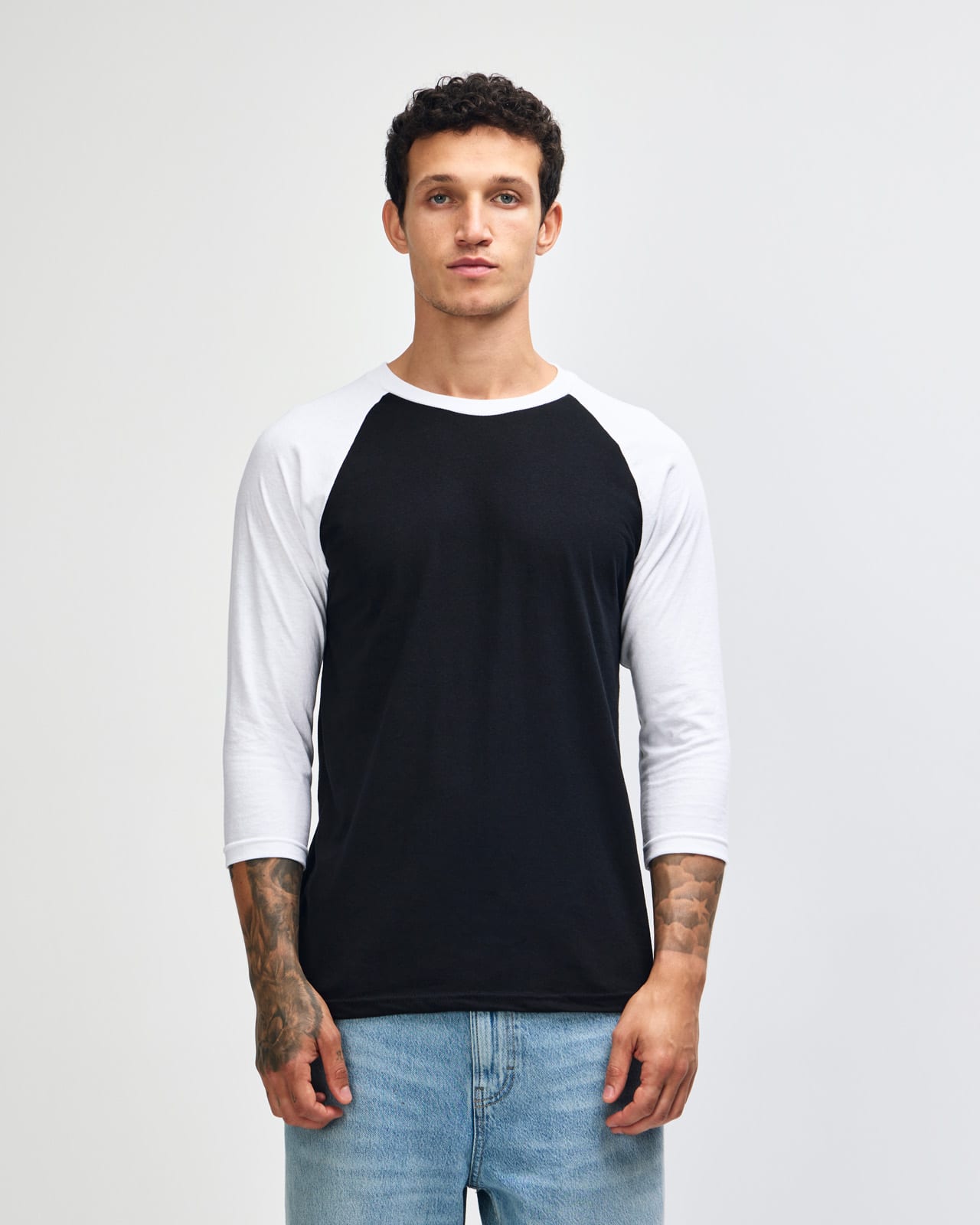 A unisex raglan T-shirt featuring black body and white sleeves, with a logo on the front. American Apparel CVC Unisex Raglan T-shirt - Image 1