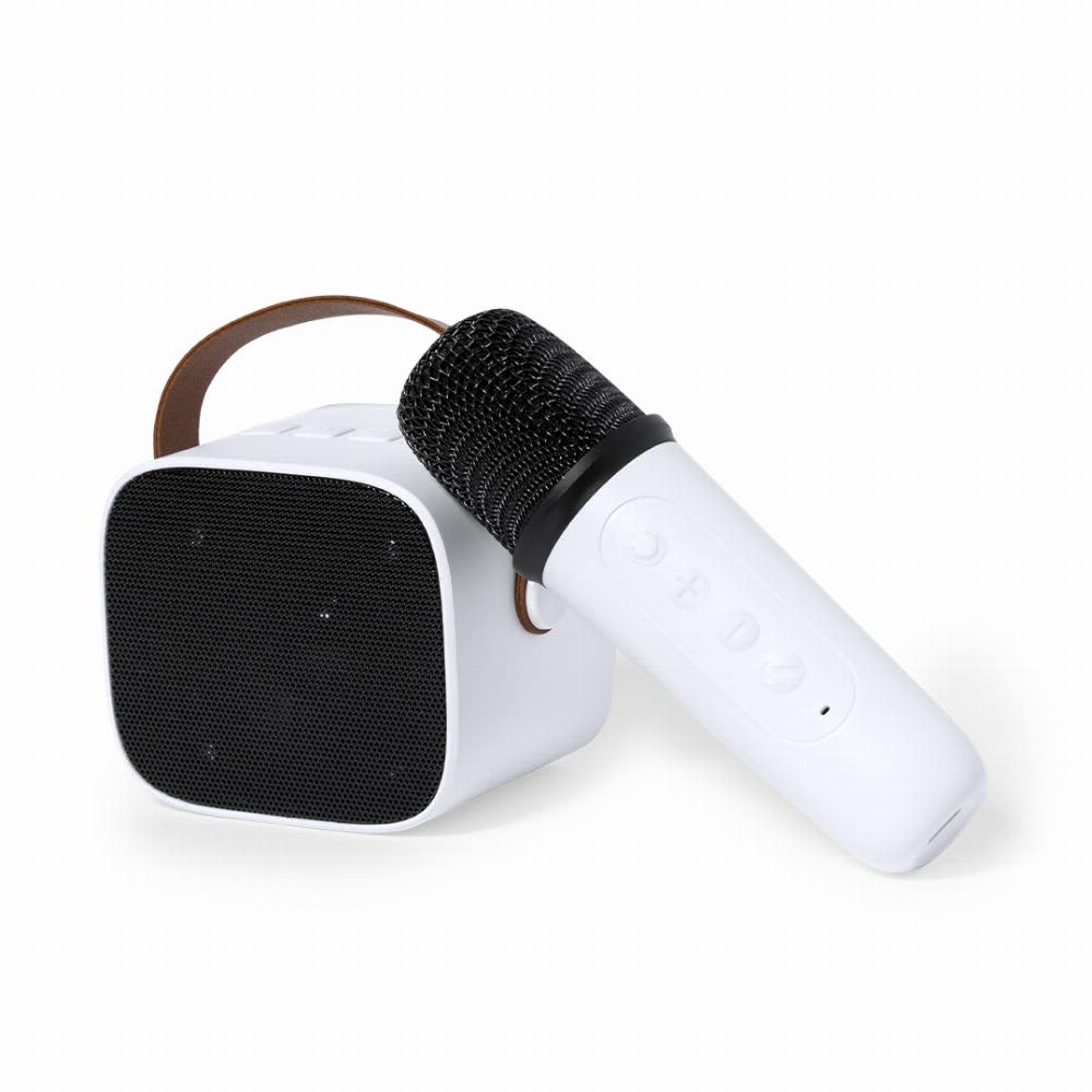 A white microphone lies beside a small white speaker with a black mesh front and a brown strap. Sophie - Image 1