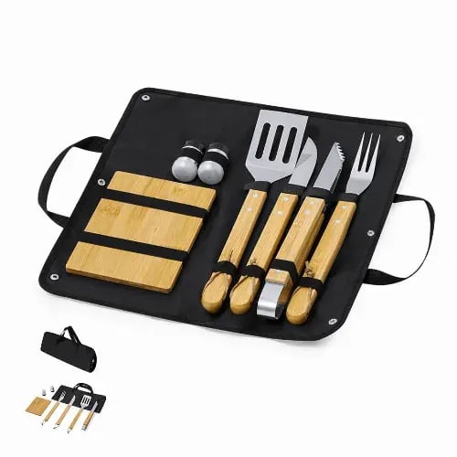 A barbecue utensil set with wooden handles, including a spatula, fork, knife, cutting board, and salt and pepper shakers, in a black carry case. Estrol - Image 1