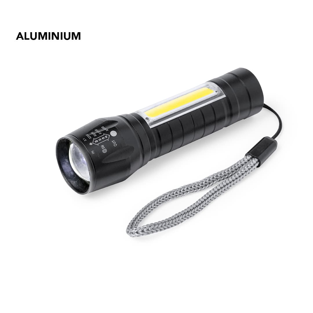 A flashlight featuring a black aluminium body, a clear lens, and a textured grip, with a wrist strap attached. Borah Torch - Image 1