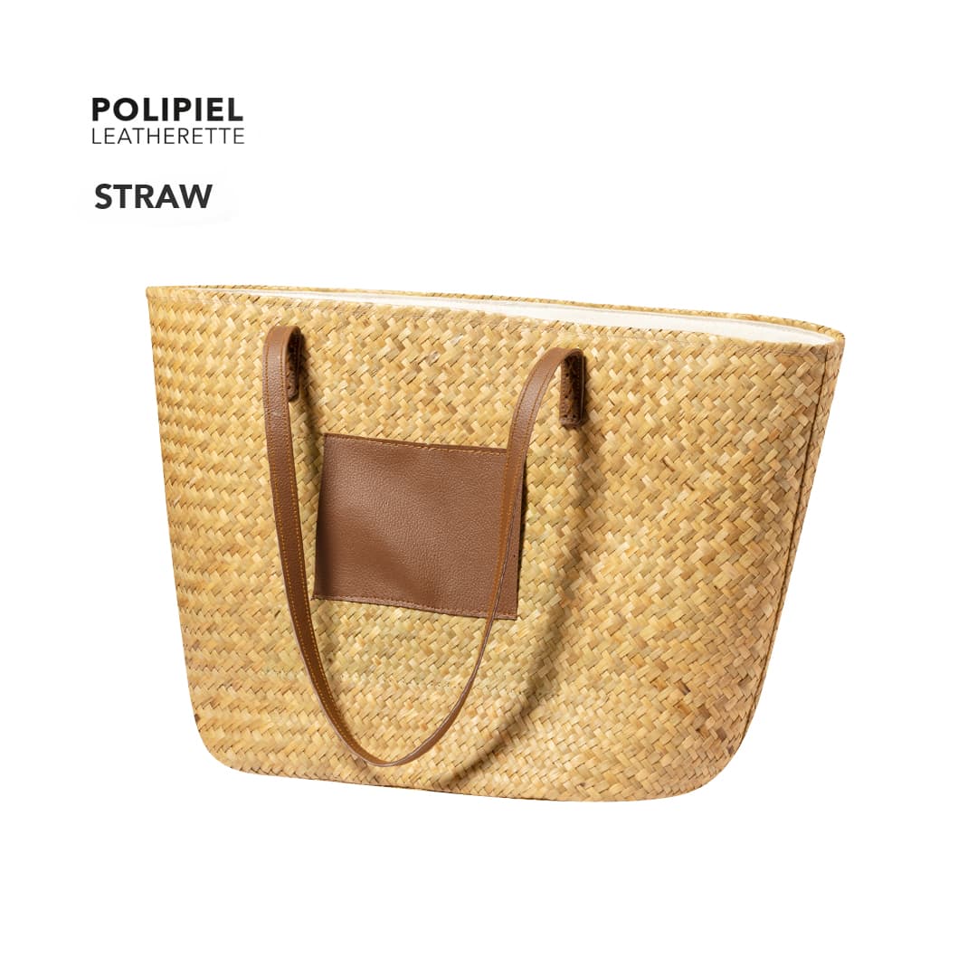 A straw tote bag with brown leatherette handles and a leatherette pocket. It features a woven texture. Moxia Bag - Image 1