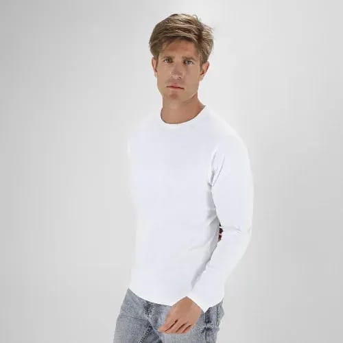 A casual white long-sleeve shirt worn by a man, paired with light grey jeans. The model stands against a plain background. Plint - Image 1