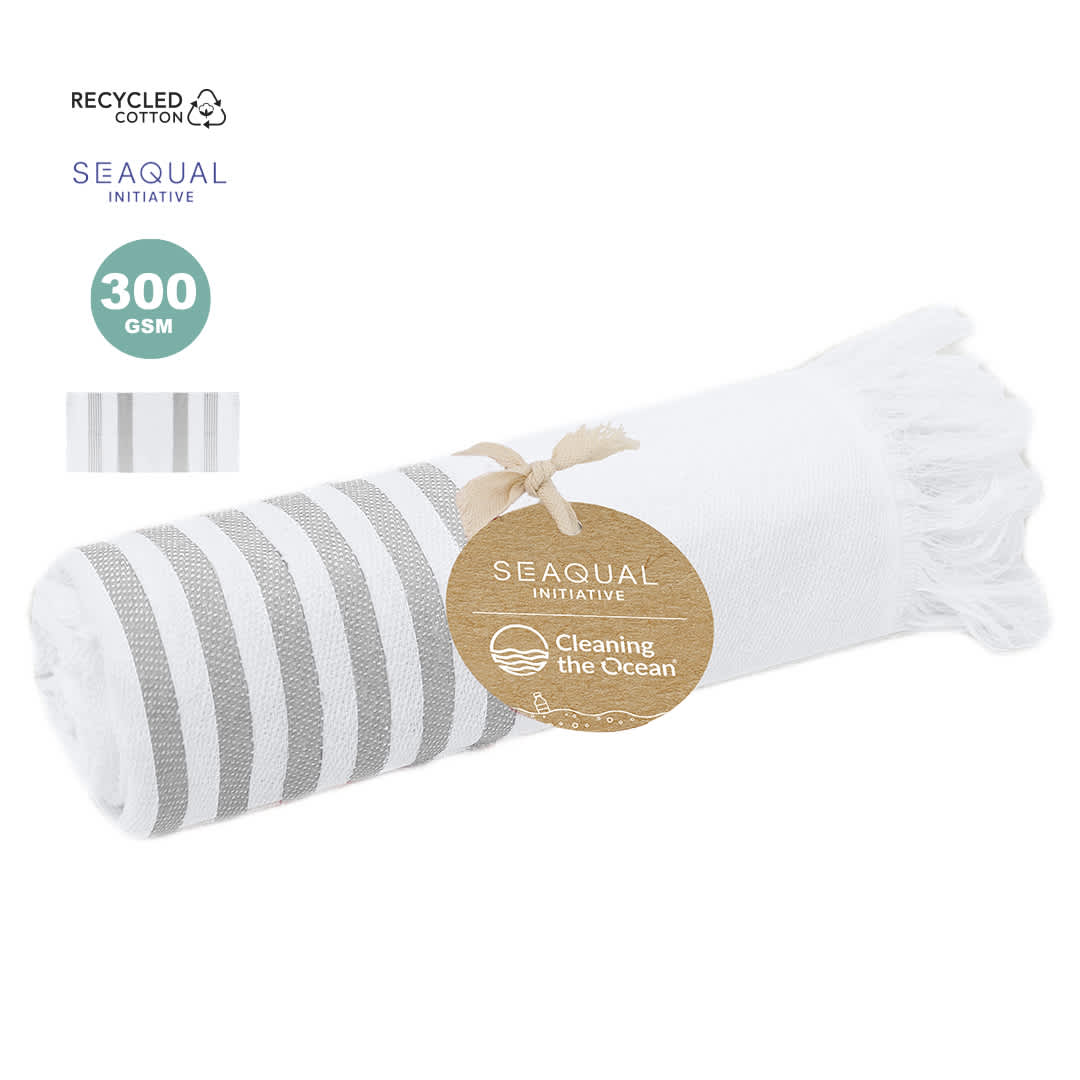 A rolled white and grey striped towel with fringing, featuring a logo and marked as made from recycled cotton. Tirling Towel Pareo - Image 1