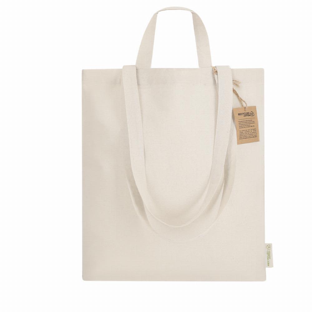 A tote bag in a natural, light cream colour with long handles and a small tag attached. Drulik - Image 1