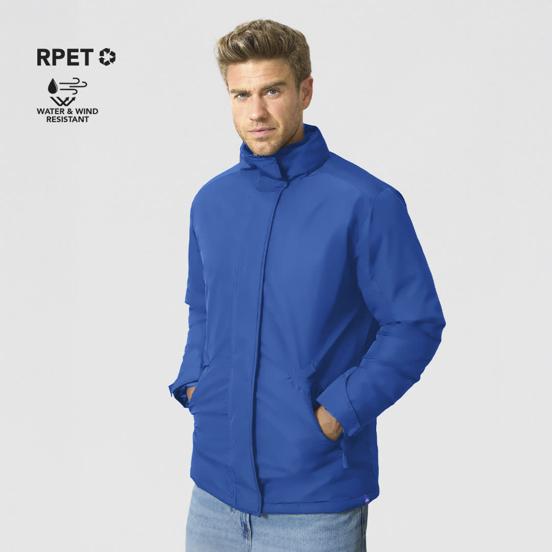 A blue puffer jacket with a high collar and a logo, displayed on a model against a grey background. Oceanía Parka - Image 1
