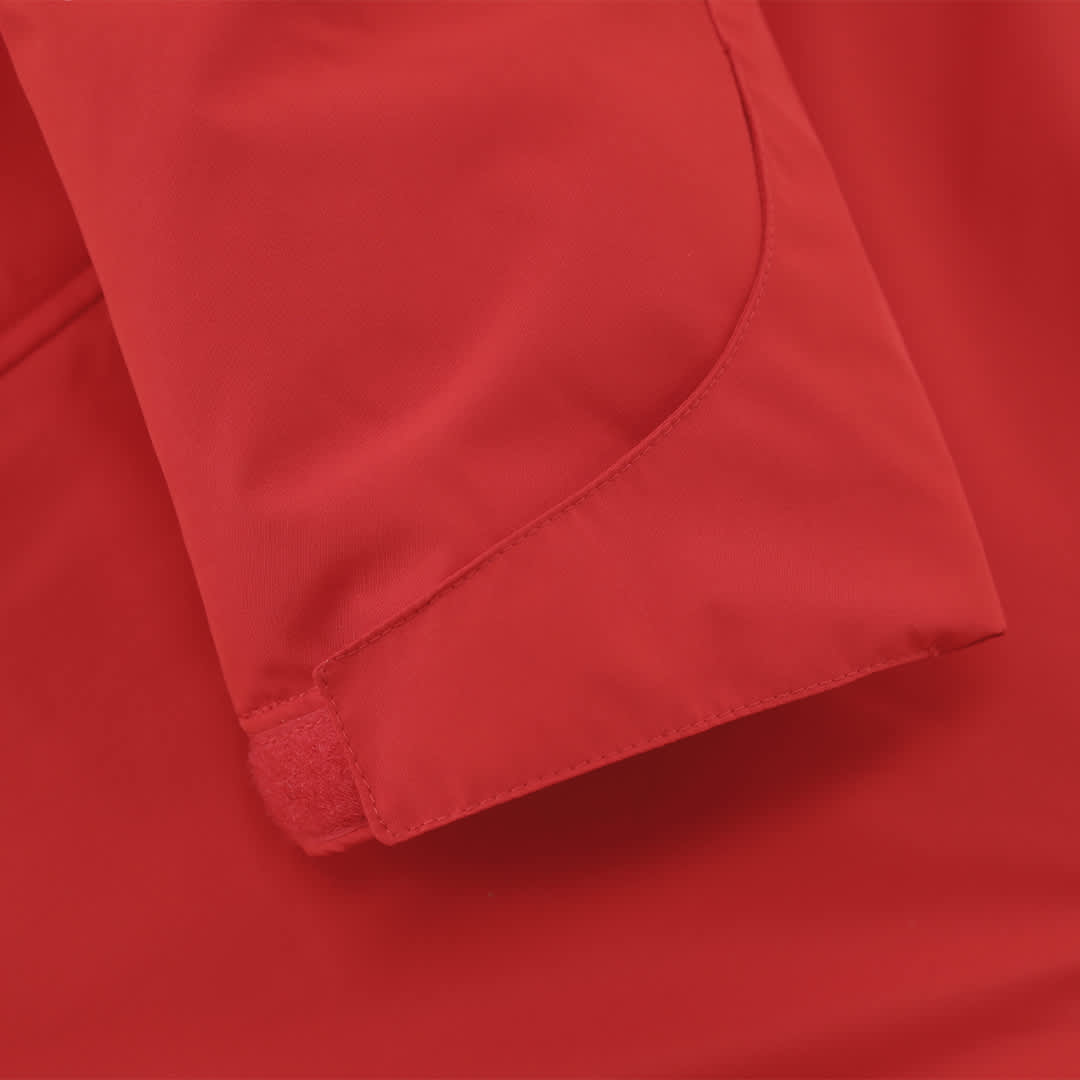 A close-up of a red jacket sleeve featuring a velcro closure and smooth fabric. It has a logo on the sleeve. Oceanía Kids Parka - Image 1