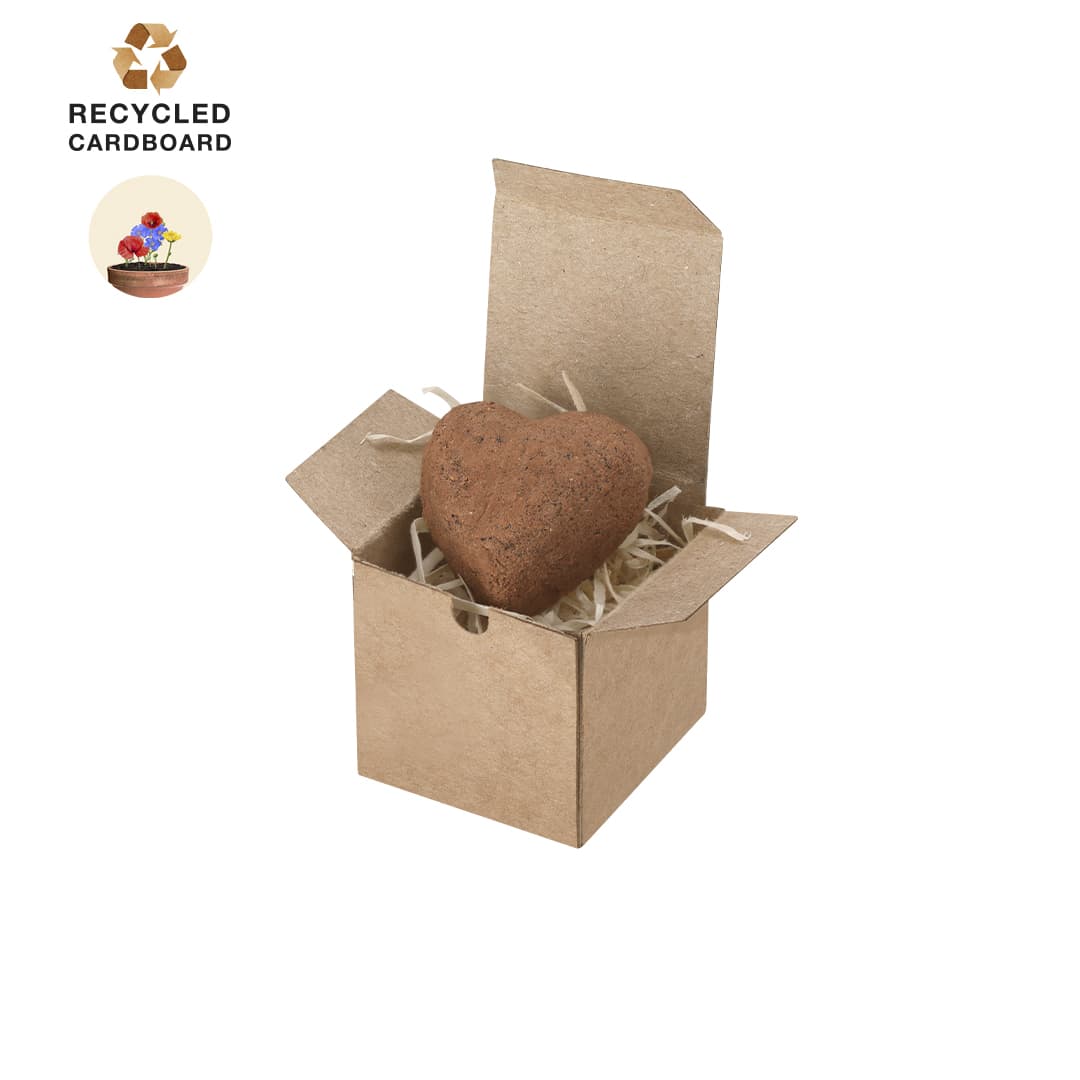 A heart-shaped bonbon nestled in a recycled cardboard box, surrounded by shavings. The box is open, revealing the treat inside. Fobin Heart Bonbon Box - Image 1
