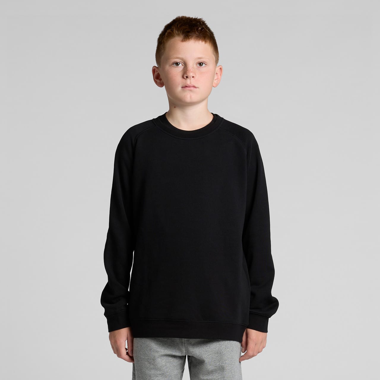 A black jumper sweater for youth, featuring a classic design and a relaxed fit. It has a branding logo. Youth Supply Crew - Image 1