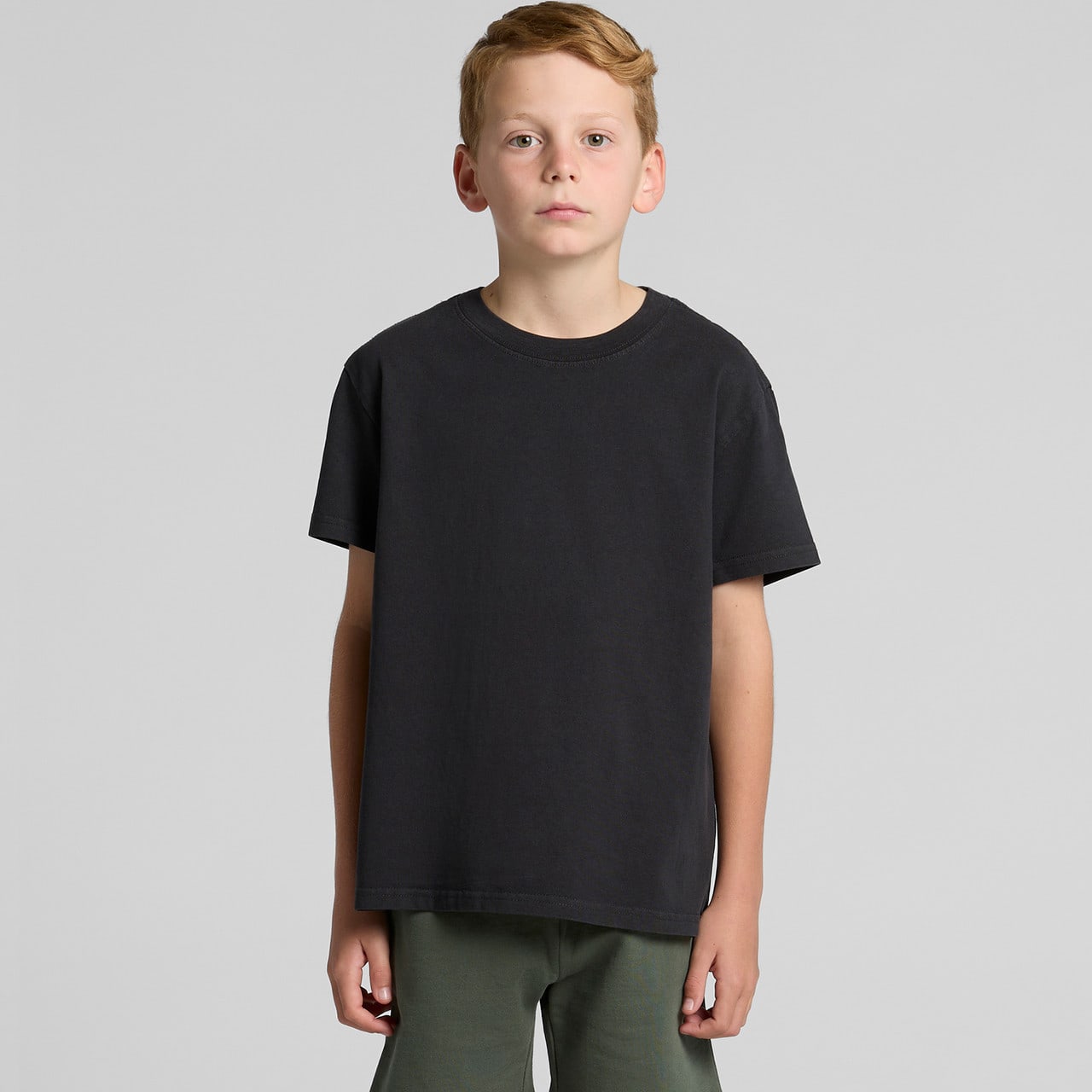 A youth heavy faded tee in black, displayed on a model against a plain background. The shirt features a logo. Youth Heavy Faded Tee - Image 1
