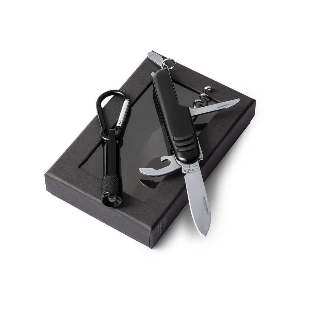 A black multi-tool with a knife, screwdriver, and bottle opener, packaged in a black box with a carabiner. Sufli Set - Image 1