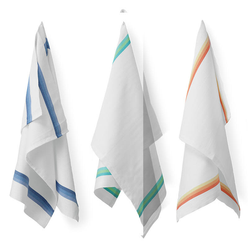 Three kitchen towels in white, featuring blue, green, and orange stripes. The towels are hanging and have a simple design. Torcione Kitchen Towel (12 pack) - Image 1