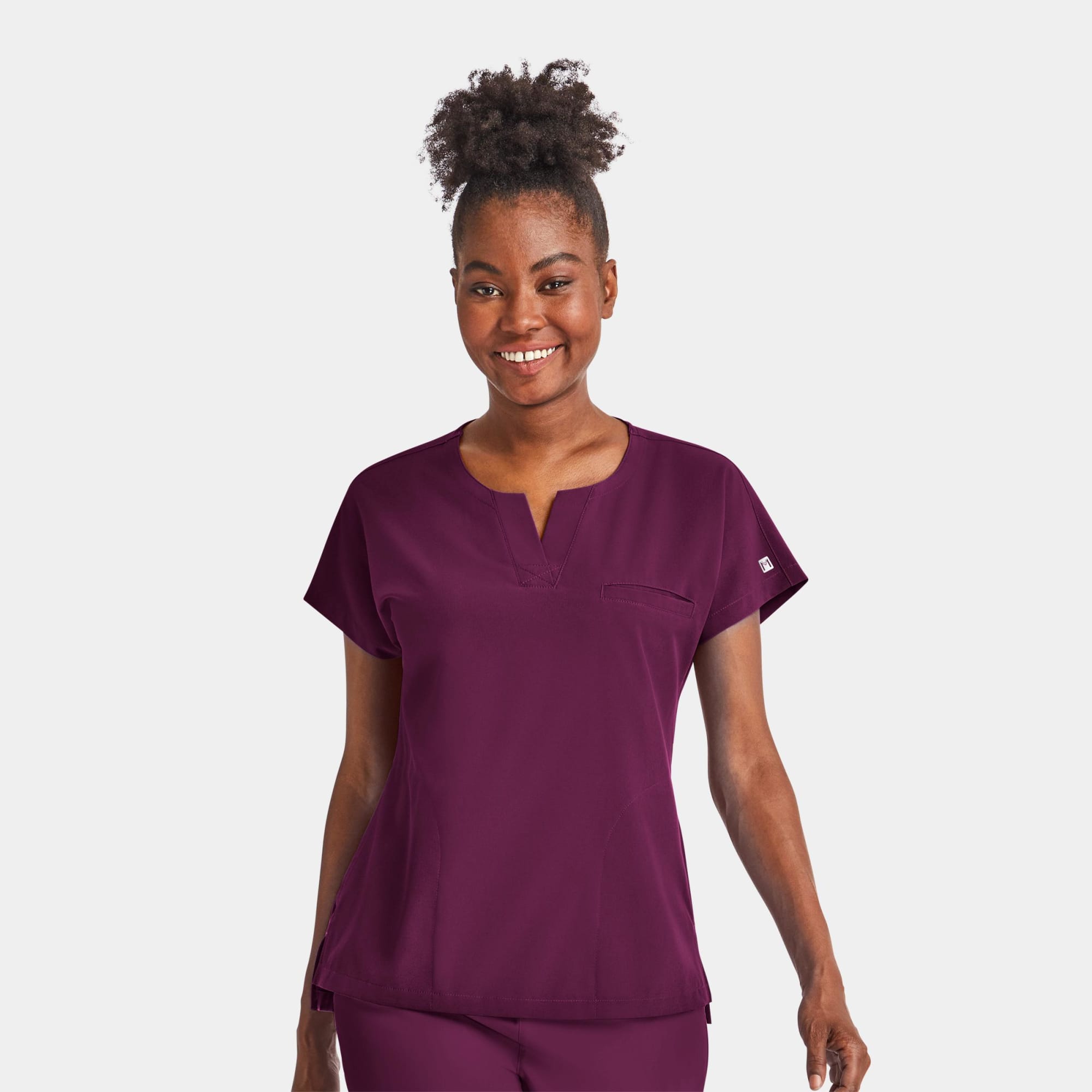 A women's notched neck dolman top in burgundy, featuring short sleeves and a chest pocket. The top has a logo. Matrix Impulse Womens Notched Neck Dolman Top - Image 1
